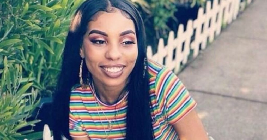 Nia Wilson smiling in a multi colored t-shirt.