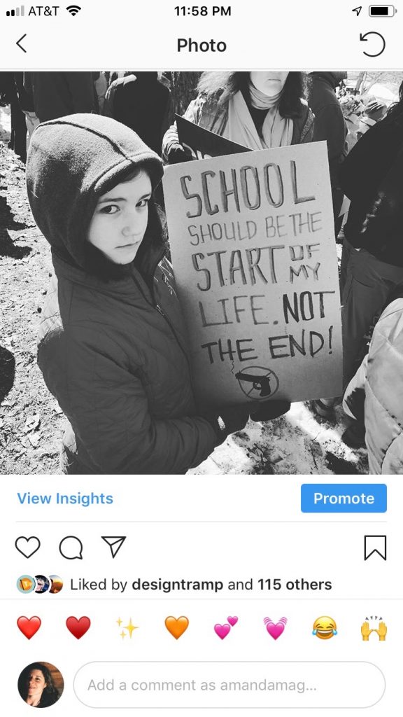 A young girl holds a cardboard sign at an anti-gun rally. It reads "School should be the start of my life, not the end."
